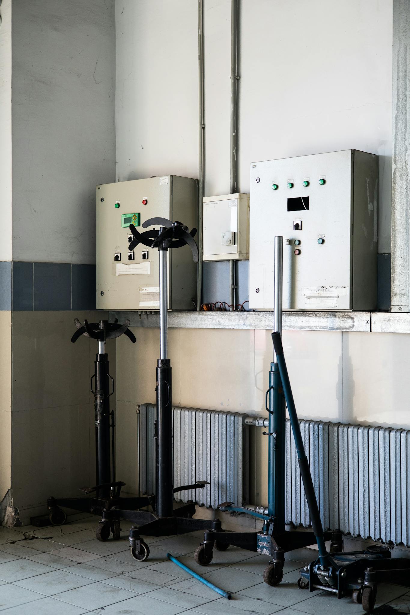 An industrial workshop with tools and electrical panels lined against a wall.